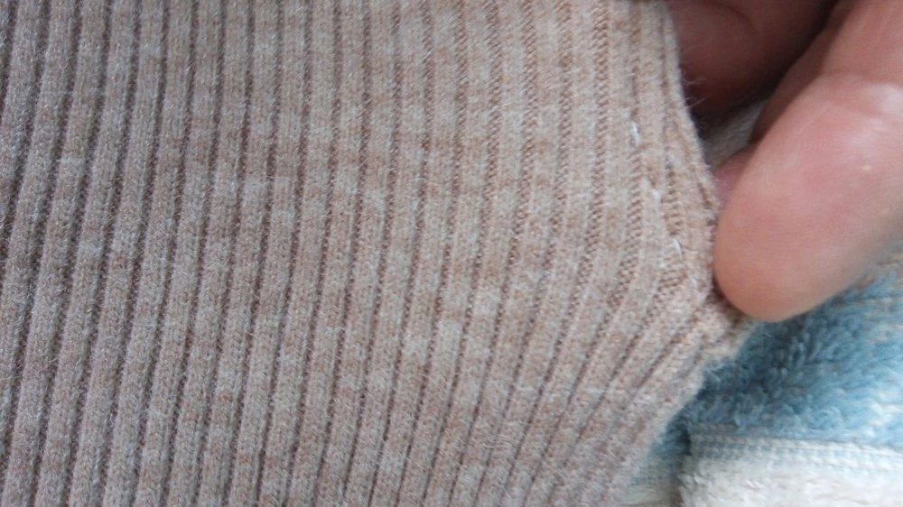 Горловина ушита по бокам белыми нитками, ручной шов.