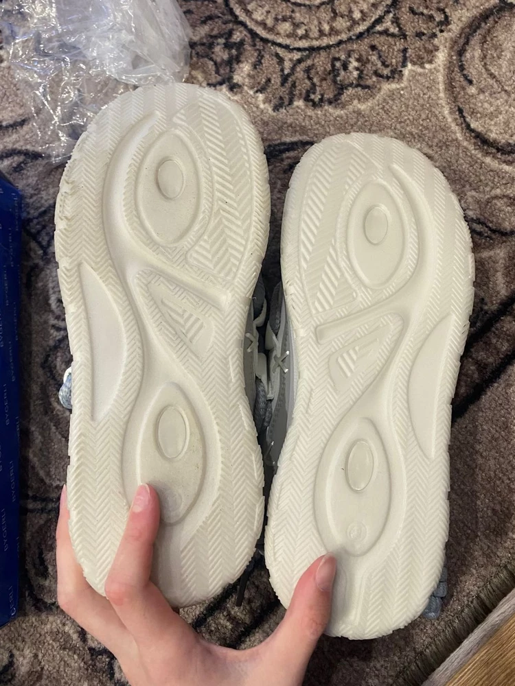 Начну с того, что кроссовки хорошие, красивые, запах не большой присутствует, но это не критично. Возмутило, что пришли они вот так "хорошо упакованы", драная коробочка, а на неё натянута тоненькая резиночка. Правый кроссовок примерялся кем-то и судя по его подошве грязной и потёртостям на боковых сторонах не один раз. Но так, как дочери они очень понравились, одну звезду убираю за этот казус. Размер ноги у дочери 39-40, 41 подошёл идеально.